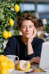 Obraz premium Young caucasian female working on laptop in lemon-filled workspace