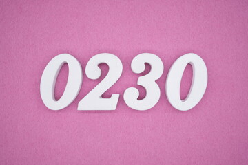 The numbers are made of white painted wood, placed on a pink paper background.