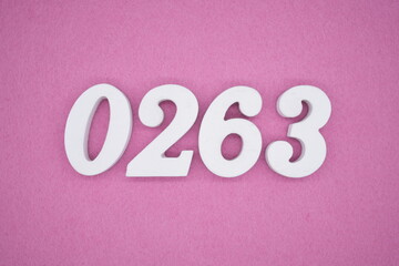 The numbers are made of white painted wood, placed on a pink paper background.