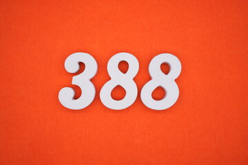 The numbers are made of white painted wood placed on an orange paper background.