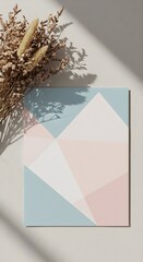 Geometric abstract pattern in pastel colors on a neutral background with dried flowers and sunlight shadows. Wedding invitation card mockup with copyspace