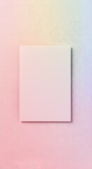Fototapeta premium Vertical shot of a blank pale pink rectangular card atop a soft pastel gradient fabric texture background. Wedding invitation card mockup with copyspace