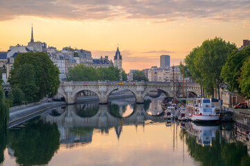 The Seine River reflects the warm colors of sunrise as Paris awakens with stunning scenery.