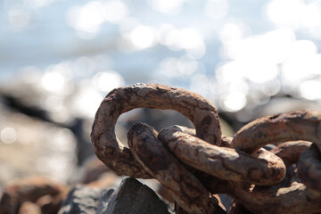 Verrostete Eisenkette am Elbstrand gegen die Sonne