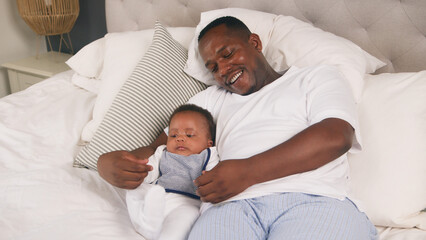 Father Bonding With His Baby While Relaxing at Home in a Cozy Bedroom Environment