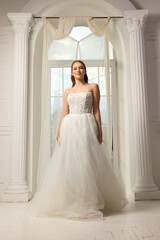 Fototapeta premium Elegant bridal portrait in a bright, airy venue during daylight hours showcasing a stunning white gown