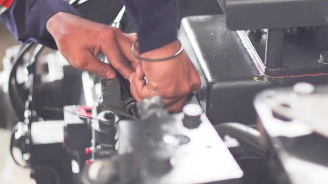 A mechanic is checking and inspecting the Komatsu D155 transmission trouble while testing the transmission on the test bench in the workshop.