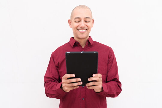 Man using digital tablet computer in burgundy shirt against white background