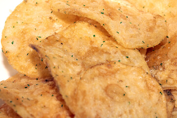 Close up of fresh potato seasoned crisps snack on a white background