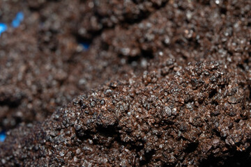 Close up of wet coffee grinds that looks like soil or mud background