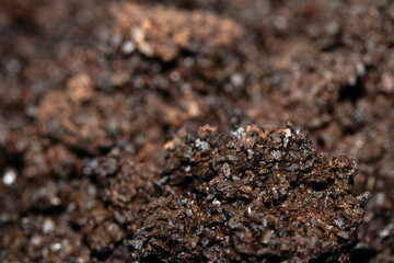 Close up of wet coffee grinds that looks like soil or mud background