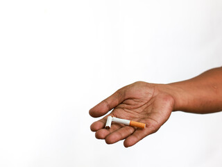 Stop smoking cigarettes concept. Close up male hand holding broken cigarettes in hand isolated on white background. Quit bad habit.