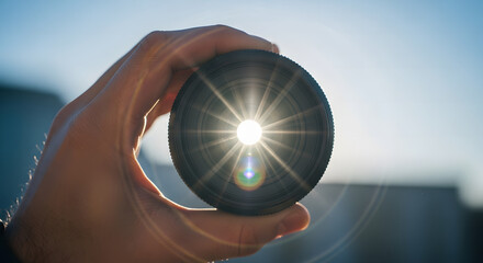 Hand Holding a Camera Lens Filter Blocking the Sun
