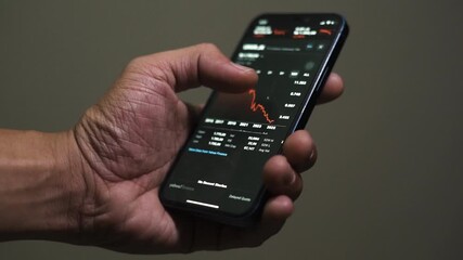 close up smartphone with stock exchange, trading Online app interface. Man hand scrolling touch screen analysing chart forex crypto currency. - Powered by Adobe