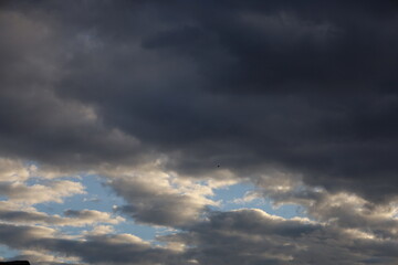 Dramatic timelapse of dark storm clouds rolling across a turbulent blue sky at sunset