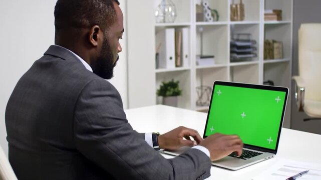 businessman working on laptop pra stap is operating a green screen computer and laptop for advertising and commercial needs