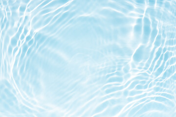 Blue water with ripples on the surface. Defocus blurred transparent blue colored clear calm water surface texture with splashes and bubbles. Water waves with shining pattern texture background.