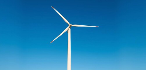 Fototapeta premium Wind turbine generating clean energy against a blue sky, nature, blades