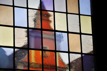 Szczyt kamienicy widziany przez kolorowe okna. © Pol Badger