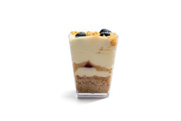Layered Dessert in a Cup Isolated on White. A dessert in a transparent cup with layers of cream, crumble, and berries. This stylish dessert is isolated on a white background.