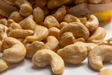 Opened bag of cashew nuts - close-up. An open snack bag full of cashew nuts shows the creamy beige color of the nuts in close-up. Light textures and natural shapes are clearly visible.