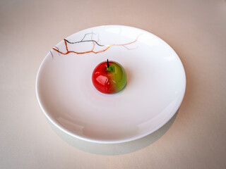 Red and green apple dessert, served on a white plate with decorative lines. It’s likely a mousse cake with a glossy glaze
