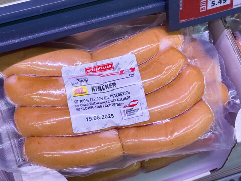 Villach, Austria - August 03, 2025: Packaged knacker sausages displayed in a grocery store, showcasing fresh meat products and vibrant packaging for culinary enthusiasts