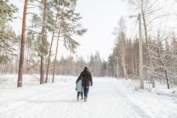 Naklejka premium Dad and daughter walking and having fun in snowy winter forest