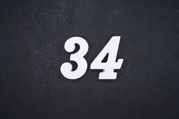 The numbers are made of white painted wood and placed on a black plastic background.