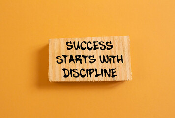 Naklejka premium Success starts with discipline message written on wood piece on orange background. Conceptual success starts with discipline symbol. Copy space.