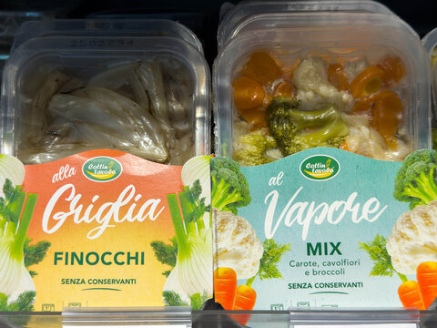 Tarvisio, Italy - August 03, 2025: Fresh vegetable packaging featuring grilled finocchi and steamed vegetable mix, showcasing vibrant colors and healthy eating options in a grocery store display