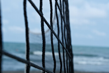 Close up of volleyball net on the beach with sea in the background