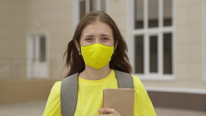 Young girl schoolgirl smiling in a protective mask, coronavirus pandemic, covid 19, safe walking around the city, helps from infections and dust, air filtration, keep healthy people safe, concept.