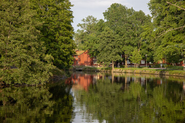 Scenic view of Orebro parks next to the flowing creek surrounded by natural greenery in central Sweden Orebro County