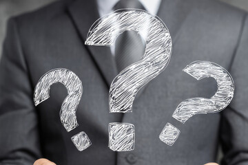 Question marks with businessman holding a tablet computer