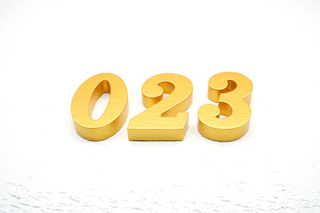 The numbers are made of gold-painted wood, placed on a white background.