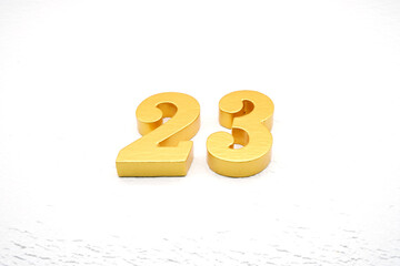 The numbers are made of gold-painted wood, placed on a white background.
