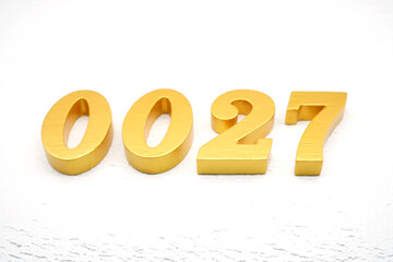 The numbers are made of gold-painted wood, placed on a white background.