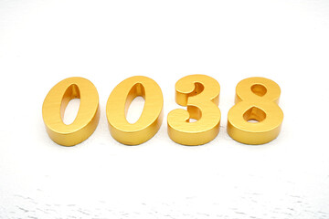 The numbers are made of gold-painted wood, placed on a white background.