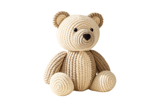 Beige crocheted teddy bear with dark ears sitting upright with gentle expression, isolated on a transparent background