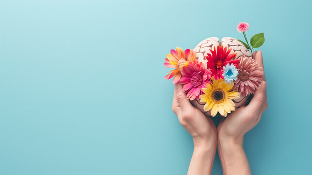 Hands holding paper head, human brain with flowers, self care and mental health concept, positive thinking