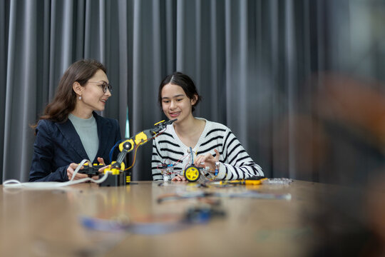 Teacher working with children engineering classroom education stem technology school. Students learning innovation electronic diy robot robot human hand. showcasing creativity and learning.