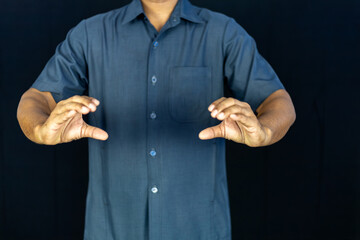 Fototapeta premium a man in a blue shirt extending his other hand with the palm. This versatile gesture can represent various concepts , making it ideal for business, financial, technological, and conceptual designs.