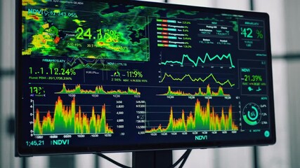 Computer screens revealing normalized difference vegetation index data, displaying changing percentages, intricate graphs, and environmental monitoring metrics - Powered by Adobe