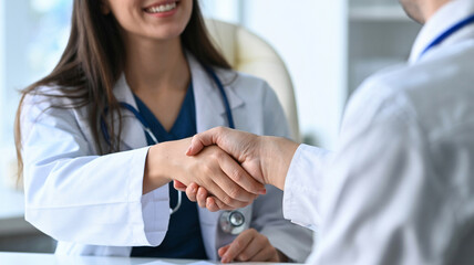 Doctors shaking hands, reaching an agreement on a patient's health, treatment plan, or diagnosis in a clinic, representing collaboration in healthcare and medicine. Doctor and patient shaking hands