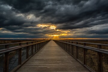 Obraz premium Dramatic sunset over a boardwalk trail