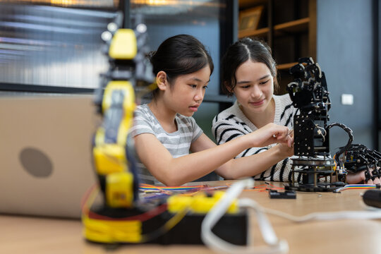 Students girl engineering classroom education stem, installation or repair programming robotic arm. Environment features classroom with technology tool, enhancing creativity and learning. - Powered by Adobe