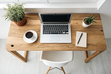 Overhead view of a wooden desk with laptop and coffee