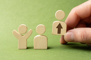 Hand placing a wooden figure with an upward arrow, signifying career advancement,  amongst two other figures