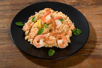 Delicious Shrimp Risotto on a Black Plate, Garnished with Herbs